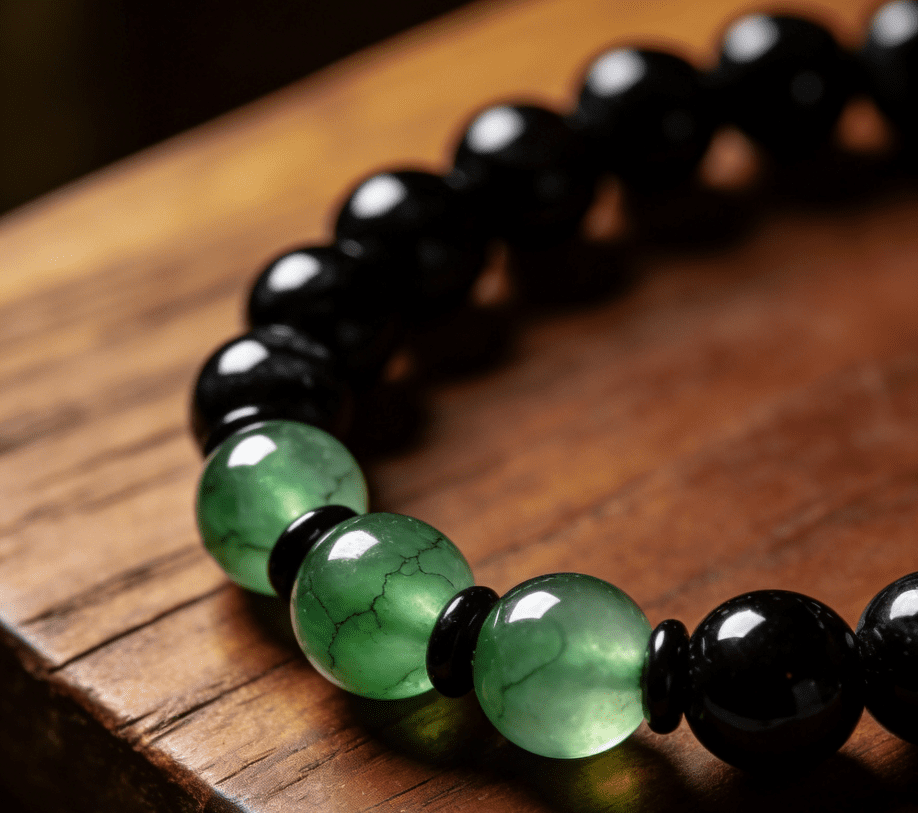 Capricorn ambitious mala bracelet with onyx and green jade beads on dark brown solid wood surface