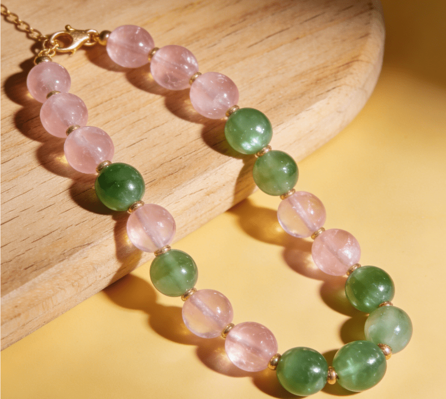 Taurus grounding mala bracelet with rose quartz and green aventurine beads on wooden cutting board