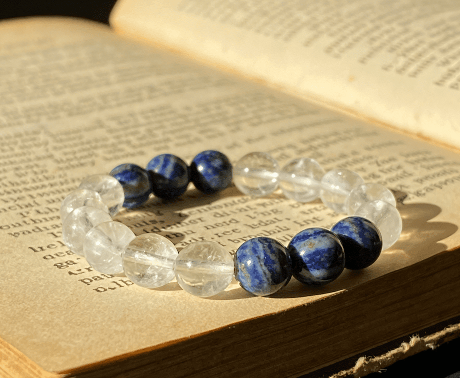 Gemini communication mala bracelet with clear quartz and blue lace agate beads on open vintage book pages