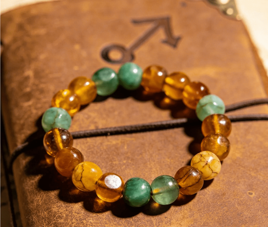 Sagittarius adventurous mala bracelet with amber and aventurine beads on vintage leather travel journal