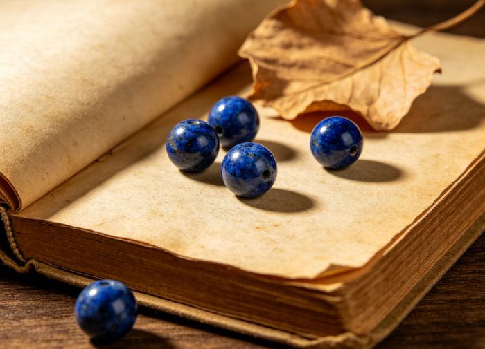 Lapis lazuli beads on vintage book pages