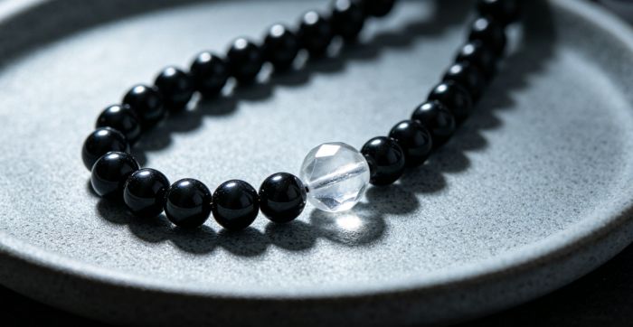 Obsidian mala on ceramic tray